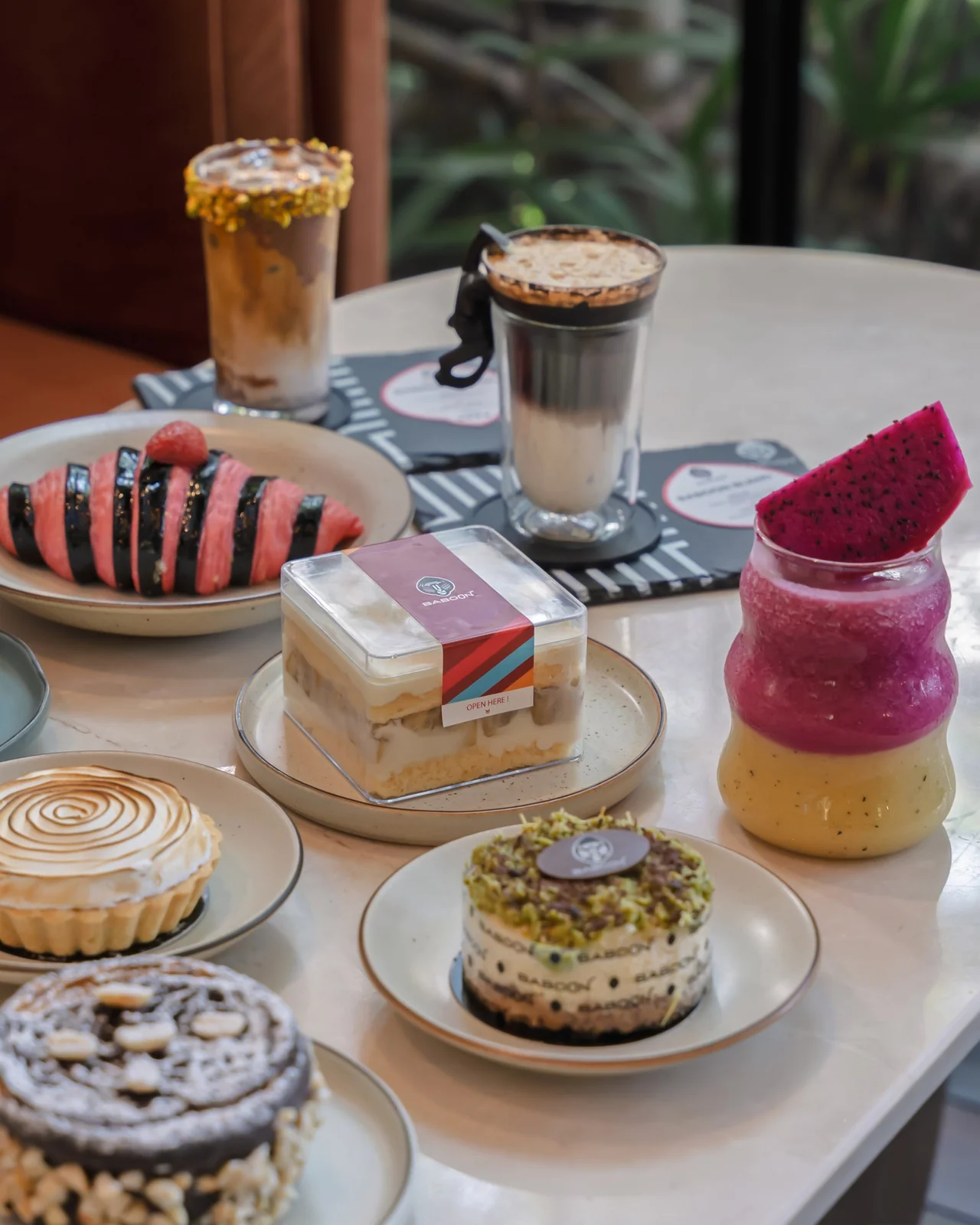 Assorted cakes, pastries and drinks arranged on a Baboon table