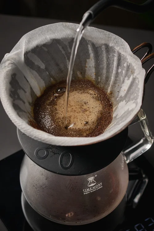 Close-up of water being poured into a coffee dripper